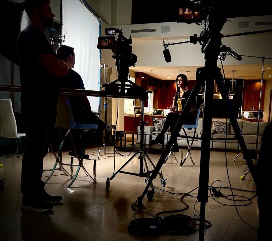 Corporate interview production setup with crew and subject on camera