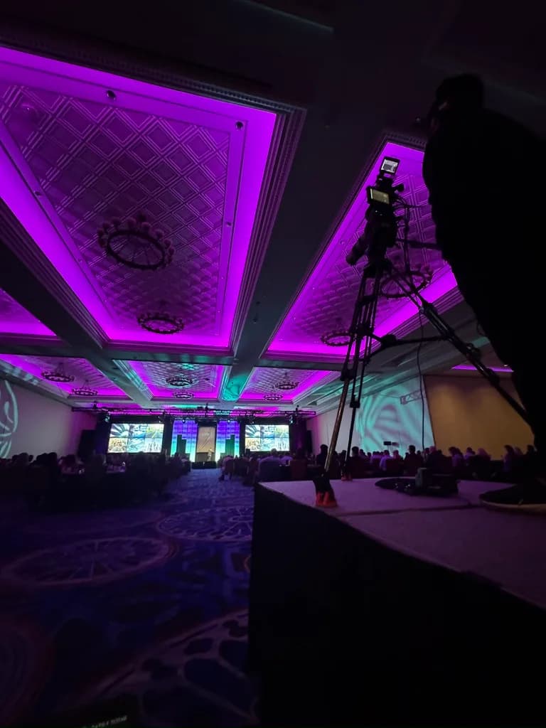 Camera operator on the convention floor capturing booth interviews